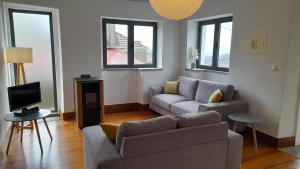 un salon avec un canapé et une télévision dans l'établissement Casa Adega, à Vale de Cameiro