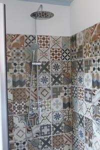 La salle de bains est pourvue d'une douche avec différents carreaux sur le mur. dans l'établissement Casa Adega, à Vale de Cameiro