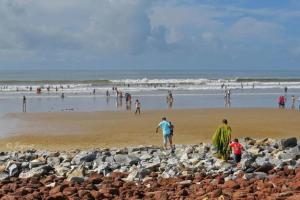 a group of people walking on the beach at Hotel Sunny New Digha Near Sea Beach View Point - Couple Friendly in Digha