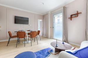 a living room with a table and chairs at MyKeypers - Luxury Flat 3BR 8P with Jacuzzi - Haussmann in Paris