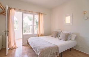 a bedroom with a bed and a large window at Can Aisha - Adults Only in Es Pujols