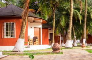 a house with palm trees in front of it at Atlantic Bay Resort, Prampram in Prampram