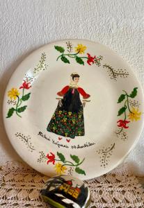 a plate with a woman in a dress with flowers at Betsanis Stafylos Apartments in Stafylos