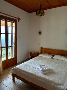 a bedroom with a large bed with a wooden headboard at Betsanis Stafylos Apartments in Stafylos