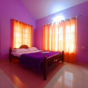 une chambre avec un lit aux murs et fenêtres violets dans l'établissement Wayanad Empire Budget Villa, à Kalpatta 3 autres photos