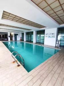 a large swimming pool in a building at Kuching 3rd Mile Japanese Style Apartment in Kuching