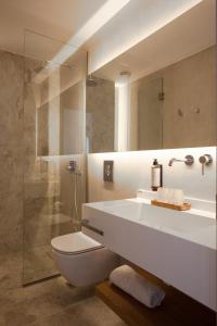 a bathroom with a sink and a toilet and a mirror at Akti Hotel Kavala in Paleo Tsifliki