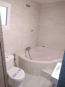 baño blanco con bañera y aseo en Hostal Pompeya Merida en Mérida