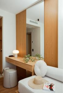 a room with a mirror and a table with a hat at Akti Hotel Kavala in Paleo Tsifliki