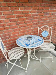 a table and two chairs sitting next to a brick wall at 3 Zimmer modern Wohnung mit Netflix und küche in Celle