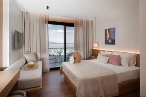 a hotel room with a bed and a balcony at Akti Hotel Kavala in Paleo Tsifliki