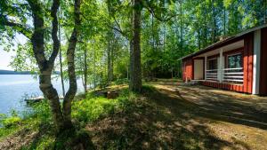 科林基拉Paimentupa Rantamökki的水体旁树林中的红色小屋