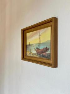 a picture of a painting of a boat on a wall at Betsanis Stafylos Apartments in Stafylos