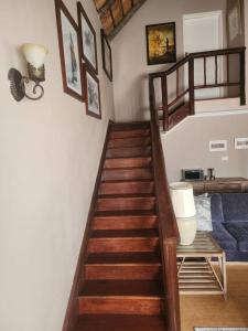a wooden staircase in a living room with a blue couch at Stone Town Guesthouse in Gaborone