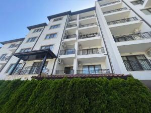 a white apartment building with people sitting on the balconies at private apartments in Apolon in Ravda