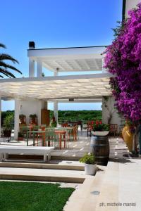 a pavilion with tables and chairs and purple flowers at Agriturismo Donna Clementina in Castellaneta Marina