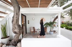 a woman in a black dress walking on a porch at Akti Hotel Kavala in Paleo Tsifliki