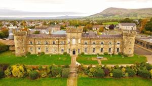 an aerial view of a castle with mountains in the background at Ballymakeever Appartment - Private Hot Tub in Derry Londonderry