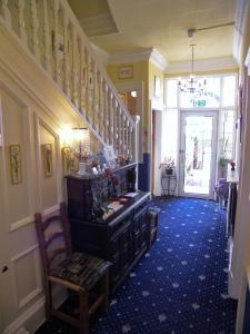 a hallway with a staircase and a chair in a room at Ardleigh House in Edinburgh