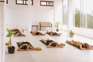 un grupo de personas tumbadas en el suelo en una clase de yoga en Stay Golden en Arugam Bay