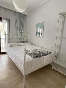 a bedroom with a white bed and a chandelier at V&Z Apartment Seaview in Ofrínion