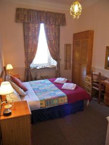 a bedroom with a bed and a desk and a window at Ardleigh House in Edinburgh