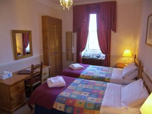 a bedroom with two beds and a desk and a window at Ardleigh House in Edinburgh +19 photos