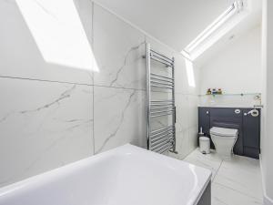 een witte badkamer met een wastafel en een toilet bij Modern Stylish Bosham Home - Pass The Keys in Bosham +70 foto's