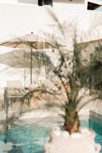 a table and chairs with an umbrella next to a pool at Petra Serenity Home in Mourné +23 photos