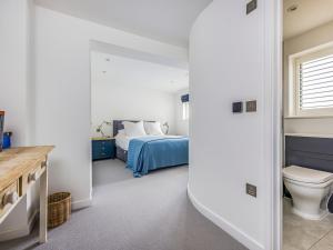 een slaapkamer met een bed en een toilet. bij Modern Stylish Bosham Home - Pass The Keys in Bosham