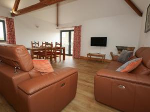a living room with a couch and a dining room at Swallows Nest in Sturminster Newton
