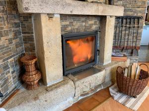 a stone fireplace with two baskets on the floor at Holiday Home Kern by Interhome in Kvasiny +27 photos
