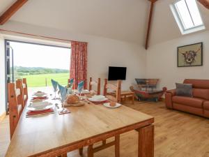 a living room with a wooden table and a couch at Swallows Nest in Sturminster Newton