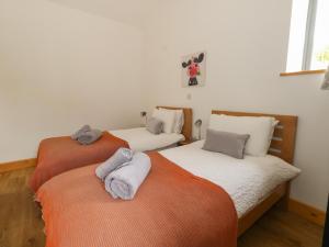 a bedroom with two beds with towels on them at Swallows Nest in Sturminster Newton