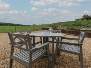 two chairs and a table with glasses on it at Swallows Nest in Sturminster Newton