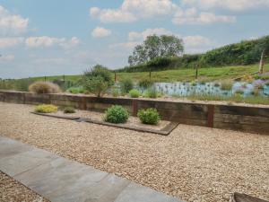 a garden with flowers and plants in a fence at Swallows Nest in Sturminster Newton