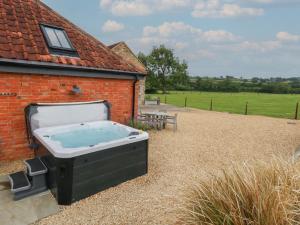 a hot tub sitting outside of a building at Swallows Nest in Sturminster Newton
