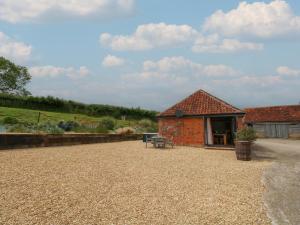 a building with a table and benches in front of it at Swallows Nest in Sturminster Newton