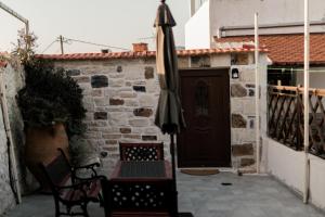 a patio with an umbrella and a table and chairs at Petra Serenity Home in Mourné