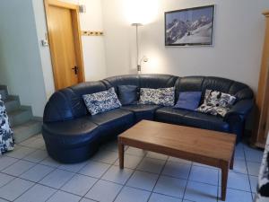 ein schwarzes Ledersofa im Wohnzimmer mit Couchtisch in der Unterkunft Apartment Mont-Fort D1 by Interhome in Siviez