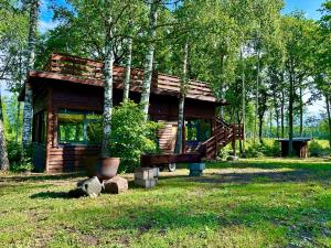 a log cabin in the middle of a forest at Lepikumäe Holiday Home with Sauna and Hot tub for up to 18 persons in Reina