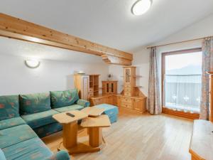 a living room with a blue couch and a table at Apartment Prieslern-2 by Interhome in Dorf