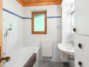 a white bathroom with a tub and a sink at Apartment Prieslern-2 by Interhome in Dorf