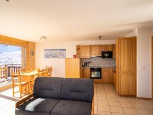 a living room with a couch and a kitchen at Apartment Les Cîmes 4 by Interhome in Les Collons