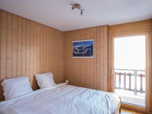 a bedroom with a bed and a large window at Apartment Les Cîmes 4 by Interhome in Les Collons