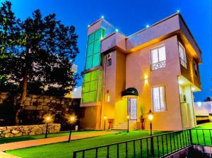 a large building with a fence in front of it at نزل فلل الريف alreef villas in Baljurashi