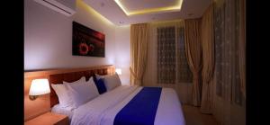 a bedroom with a large bed with blue and white sheets at نزل فلل الريف alreef villas in Baljurashi