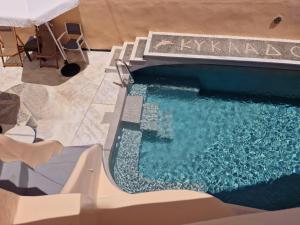 a swimming pool with chairs and a swimming pool at Kykladonisia Traditional Settlement in Fira