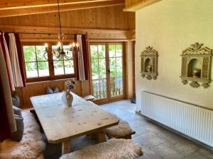 a dining room with a wooden table and windows at Apartment Sonneck by Interhome in Ramsau im Zillertal