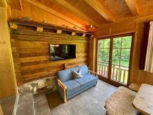 a living room with a blue couch and a tv at Apartment Sonneck by Interhome in Ramsau im Zillertal